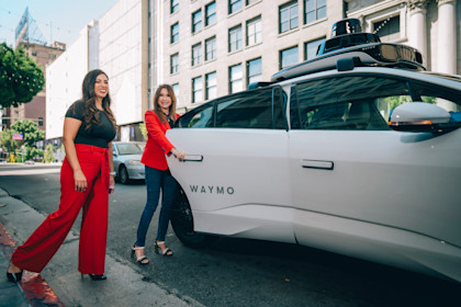 Lori and Lili entering a Waymo autonomous vehicle